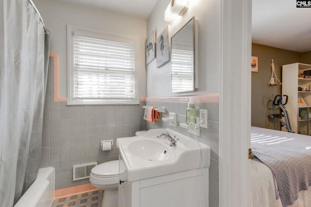 full bathroom with shower / tub combo, vanity, toilet, and tile walls