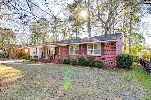 single story home featuring covered porch and a front yard