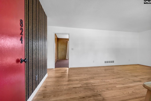 unfurnished room with light hardwood / wood-style flooring and a textured ceiling