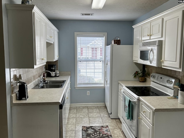 kitchen featuring backsplash, a wealth of natural light, white appliances, sink, and white cabinetry