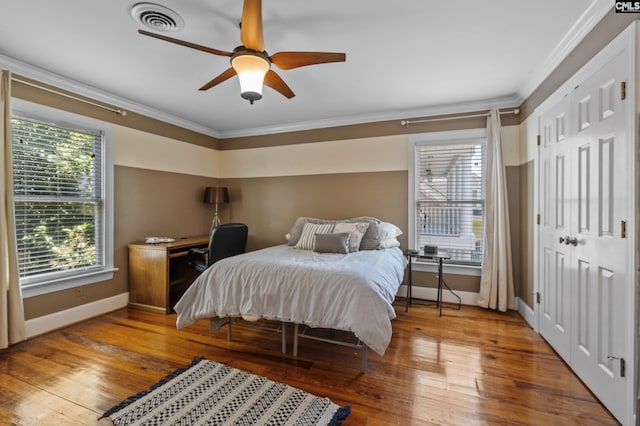 bedroom featuring ceiling fan, crown molding, and hardwood / wood-style flooring