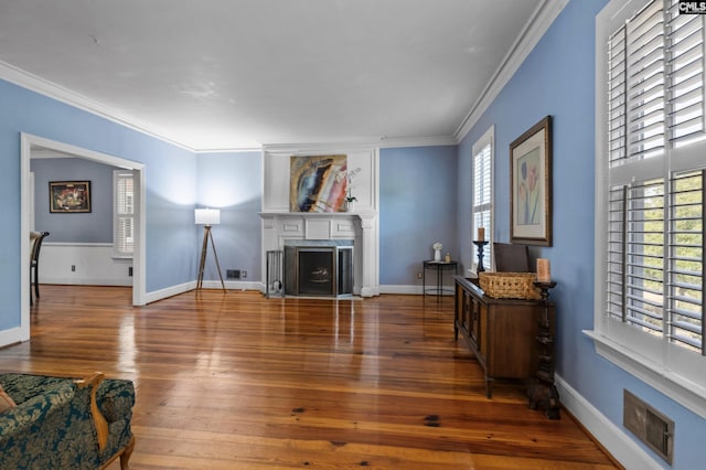 living room with a fireplace, crown molding, and dark hardwood / wood-style floors