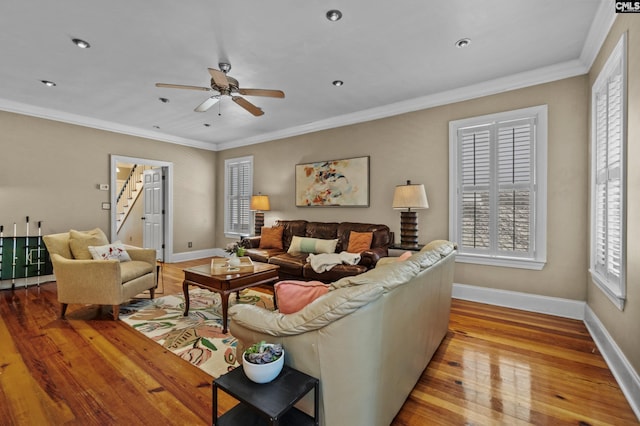 living room with ceiling fan, crown molding, and light wood-type flooring