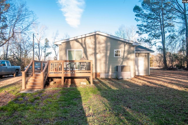 rear view of house featuring a deck, a yard, and central air condition unit