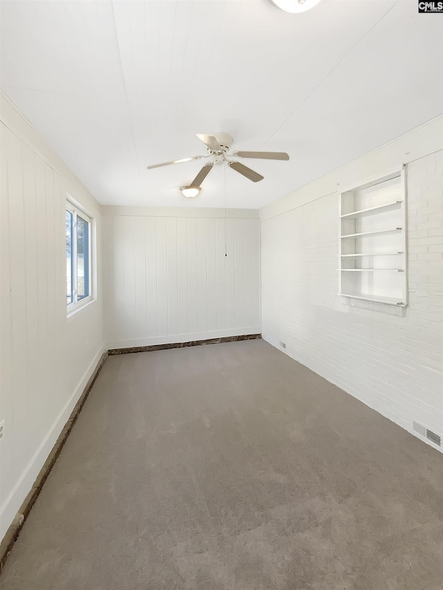 carpeted spare room featuring built in features, ceiling fan, and wood walls