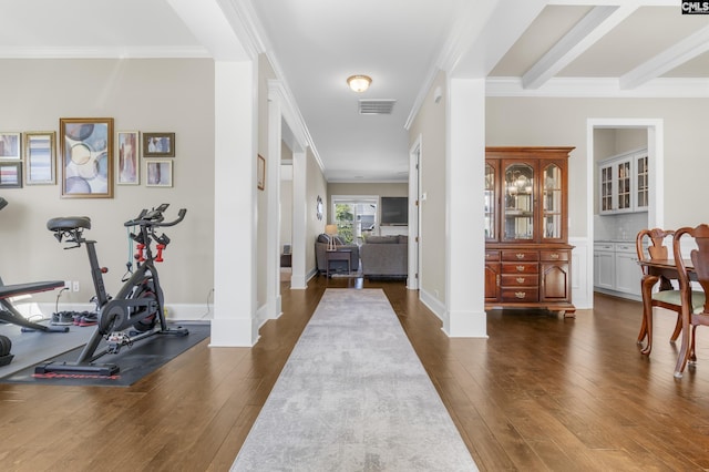 foyer entrance with beam ceiling, crown molding, and dark hardwood / wood-style flooring