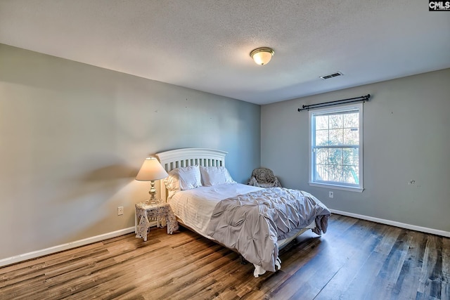 bedroom with a textured ceiling and hardwood / wood-style floors