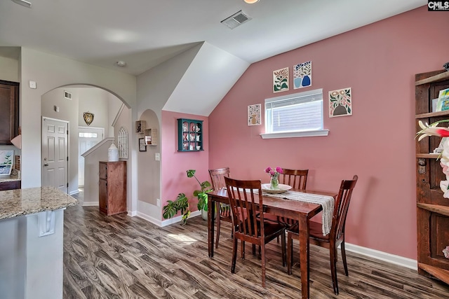 dining area with dark hardwood / wood-style flooring and vaulted ceiling