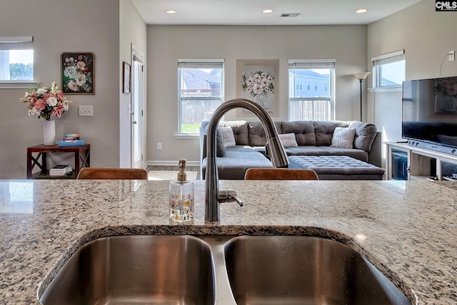 kitchen with light stone counters and sink