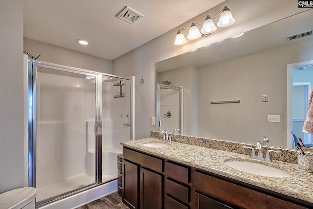 bathroom with wood-type flooring, vanity, toilet, and walk in shower