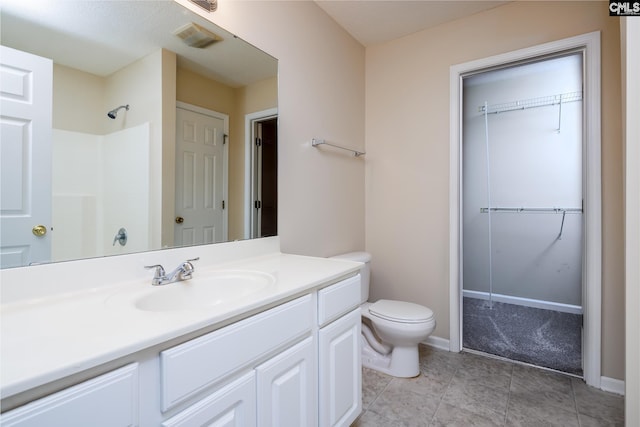 bathroom with a shower, vanity, and toilet