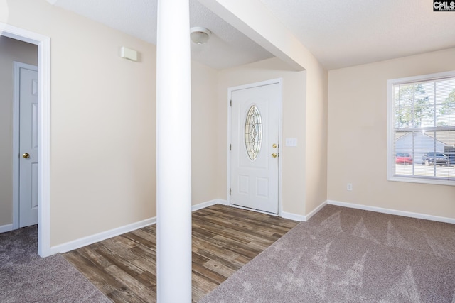 foyer entrance with a textured ceiling and dark hardwood / wood-style floors