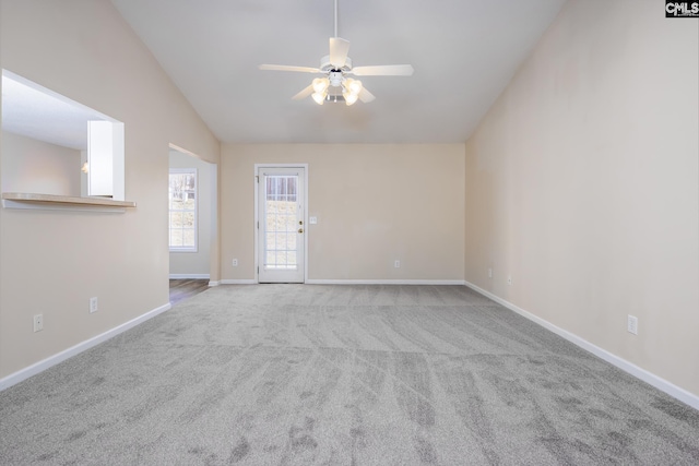 spare room featuring ceiling fan, vaulted ceiling, and light carpet