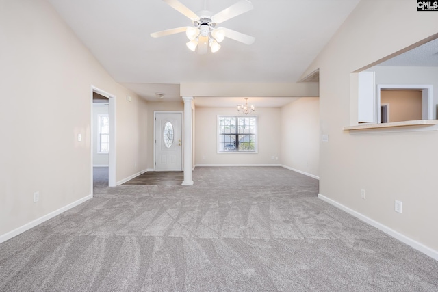 unfurnished living room featuring vaulted ceiling, carpet, ceiling fan with notable chandelier, and ornate columns