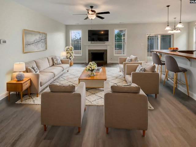 living room with hardwood / wood-style floors and ceiling fan with notable chandelier