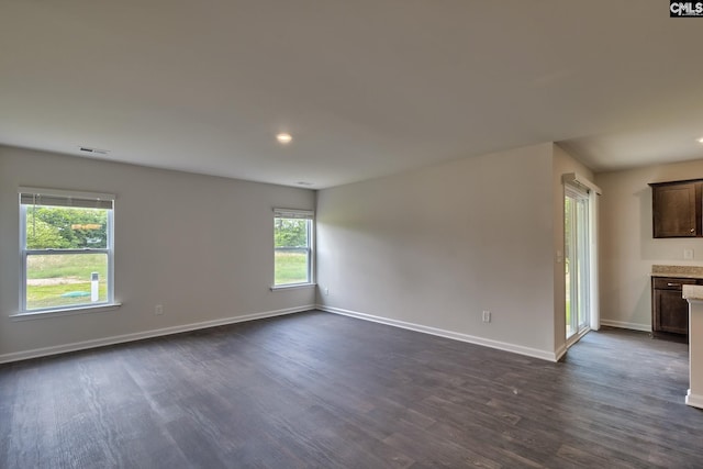 unfurnished room featuring dark hardwood / wood-style floors and a wealth of natural light