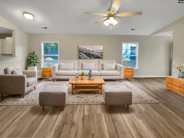 living room with hardwood / wood-style floors, ceiling fan, and lofted ceiling