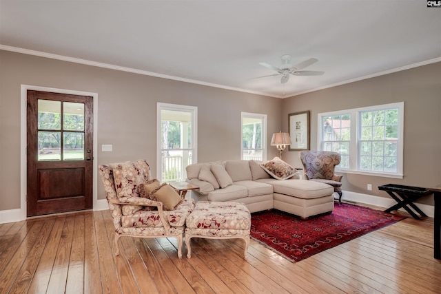 living room with hardwood / wood-style flooring, ornamental molding, and a wealth of natural light