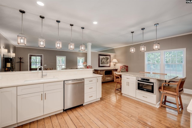 kitchen featuring pendant lighting, a kitchen breakfast bar, white cabinets, and appliances with stainless steel finishes