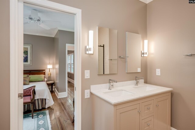 bathroom with hardwood / wood-style floors, vanity, ceiling fan, and ornamental molding