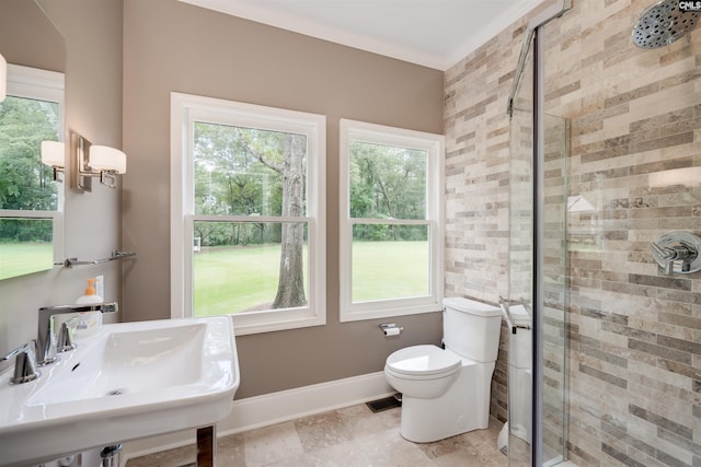 bathroom with toilet, a shower with shower door, and sink