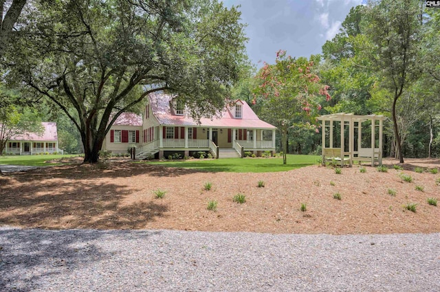 farmhouse inspired home with a front lawn and covered porch