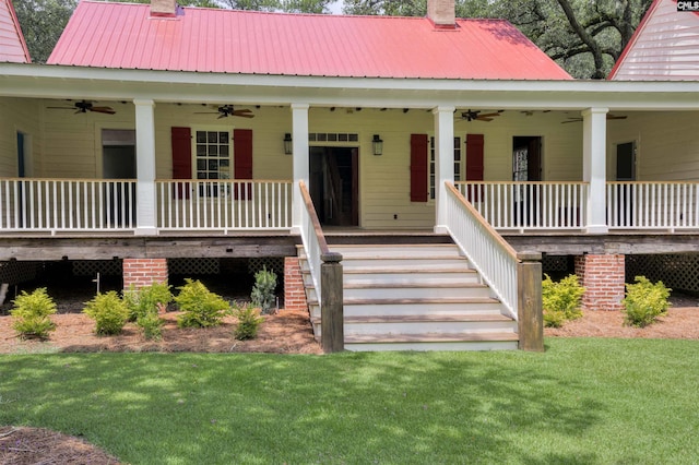 entrance to property featuring a porch, a yard, and ceiling fan