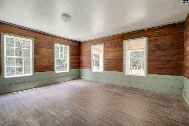 unfurnished room featuring wood walls and wood-type flooring