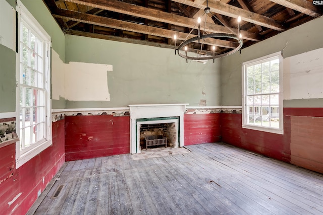 unfurnished living room featuring hardwood / wood-style floors, vaulted ceiling with beams, wood ceiling, and an inviting chandelier