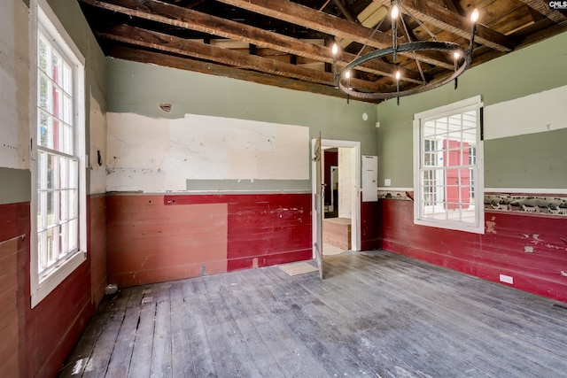 unfurnished room with a chandelier and wood-type flooring