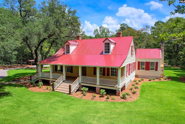 rear view of house featuring covered porch and a yard