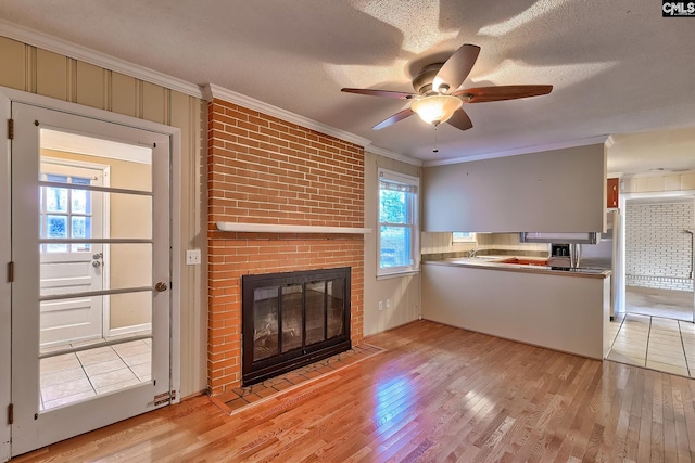 unfurnished living room featuring light hardwood / wood-style flooring and a textured ceiling