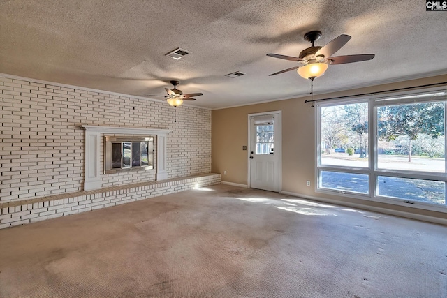 unfurnished living room featuring a fireplace, plenty of natural light, carpet, and brick wall