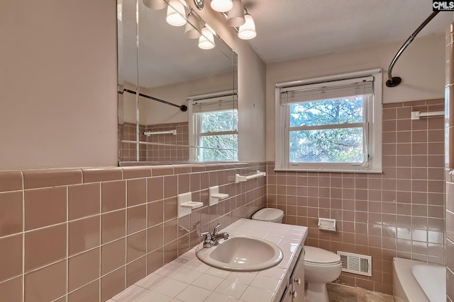 full bathroom with vanity, toilet, shower / tub combination, and tile walls