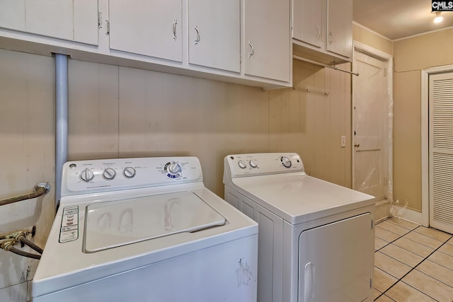 washroom featuring cabinets, light tile patterned floors, and washer and clothes dryer