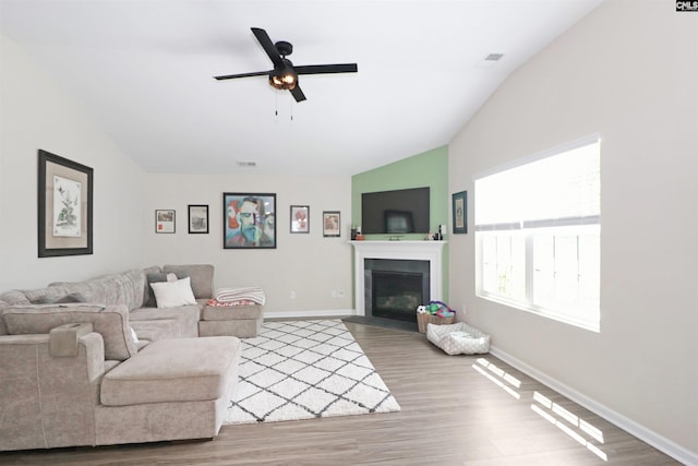 living room featuring ceiling fan, wood-type flooring, and lofted ceiling