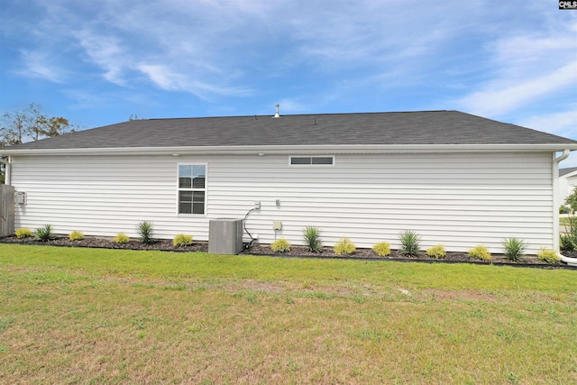 rear view of house featuring a yard and cooling unit