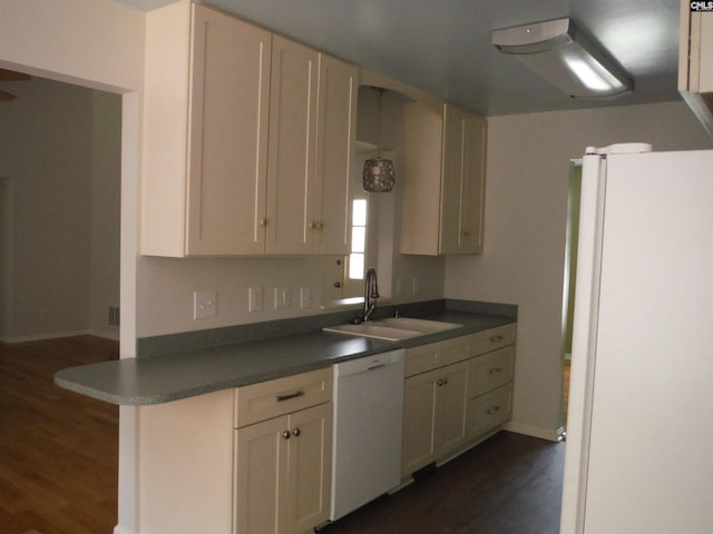 kitchen with kitchen peninsula, white appliances, sink, and dark wood-type flooring