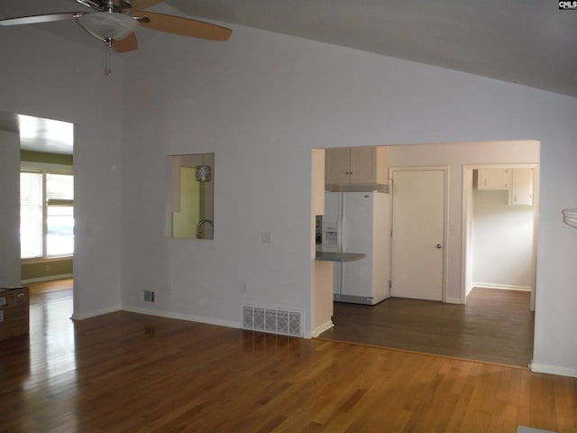 unfurnished living room with ceiling fan, dark wood-type flooring, and vaulted ceiling