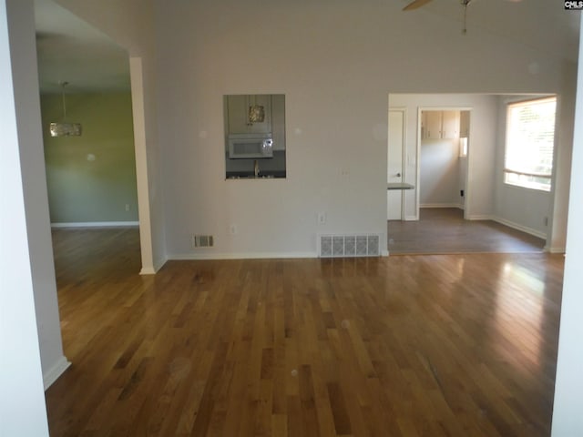 unfurnished living room featuring ceiling fan and dark hardwood / wood-style floors