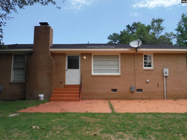 back of house featuring a lawn and a patio area