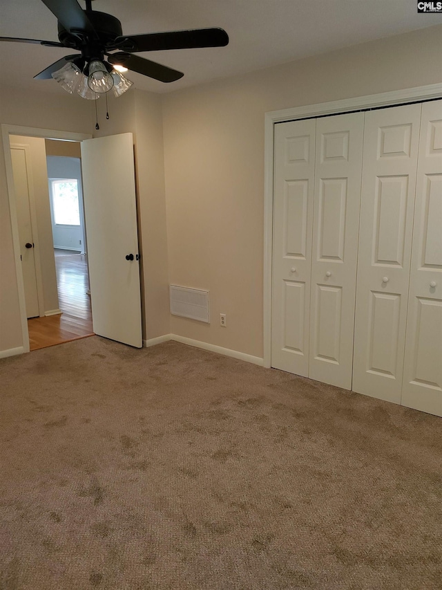 unfurnished bedroom featuring carpet, a closet, and ceiling fan