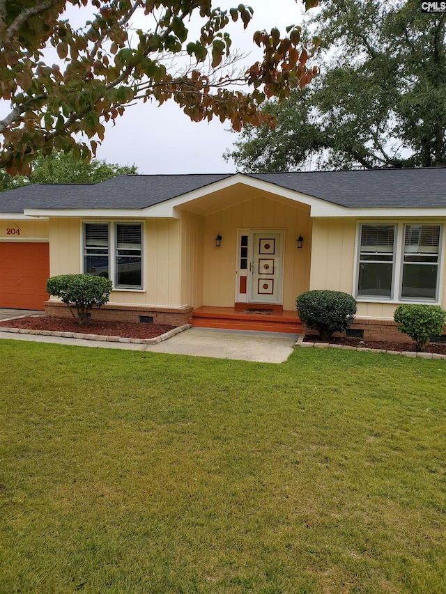 ranch-style house featuring a front lawn and a garage