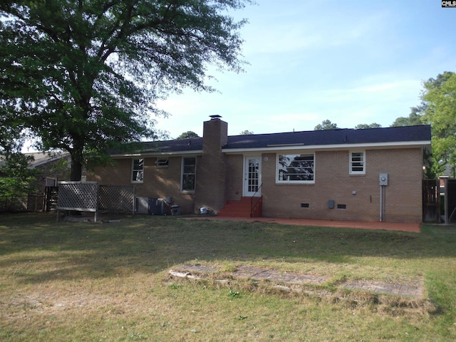 back of property featuring a lawn and a patio