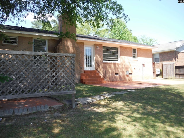 rear view of house with a lawn and a patio area