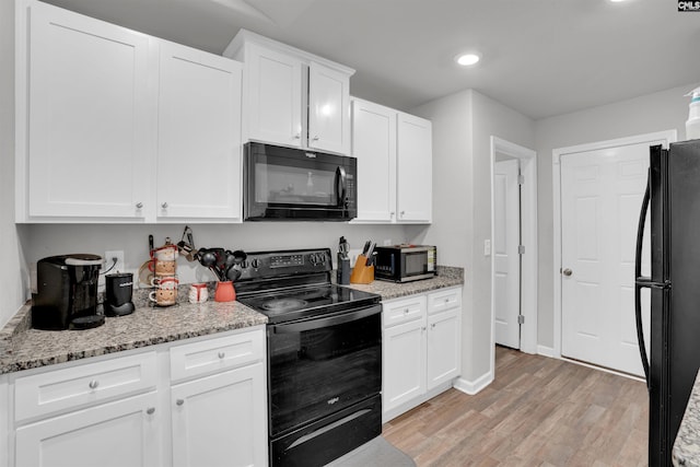 kitchen featuring black appliances, light wood-style flooring, white cabinets, and recessed lighting