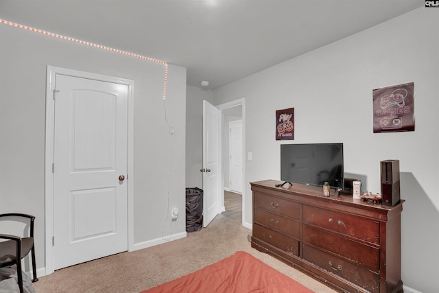 bedroom with baseboards and light colored carpet