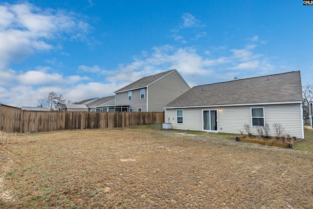 back of property featuring a yard, roof with shingles, fence, and central air condition unit