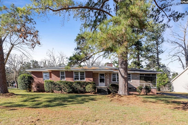 single story home featuring a sunroom and a front lawn