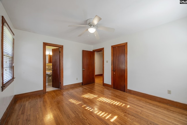 unfurnished bedroom featuring ceiling fan, light hardwood / wood-style floors, and connected bathroom